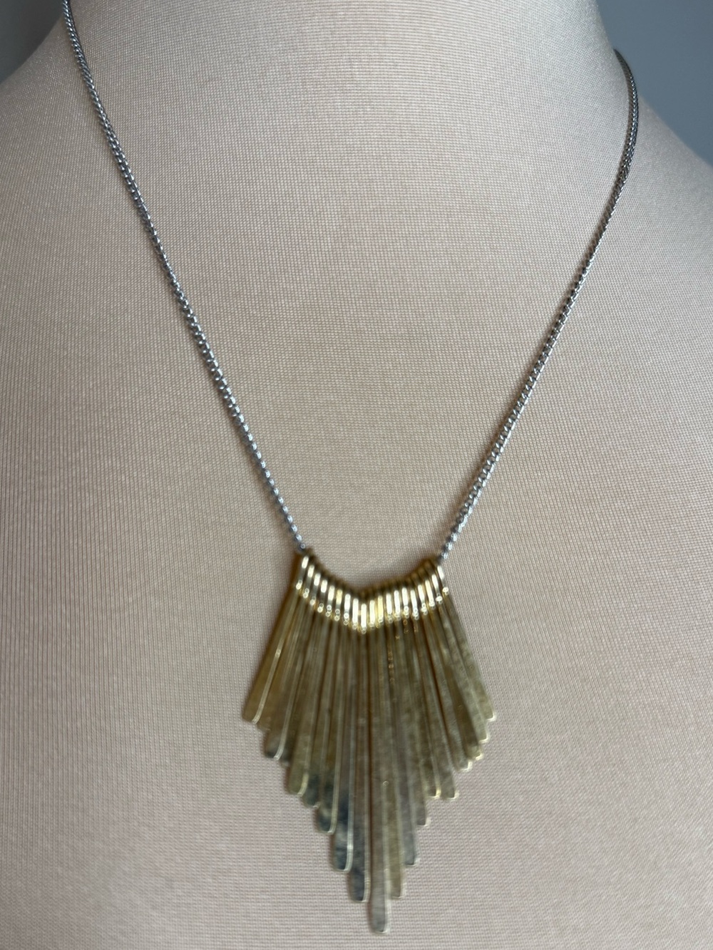 Plunder necklace with a tapered gold tone metal detail & silver tone chain